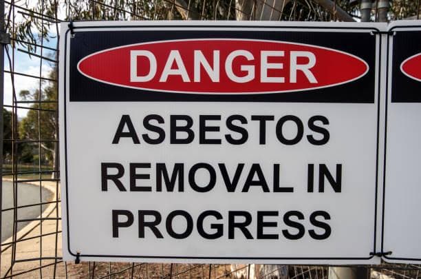 Asbestos warning signage at a work site perimeter